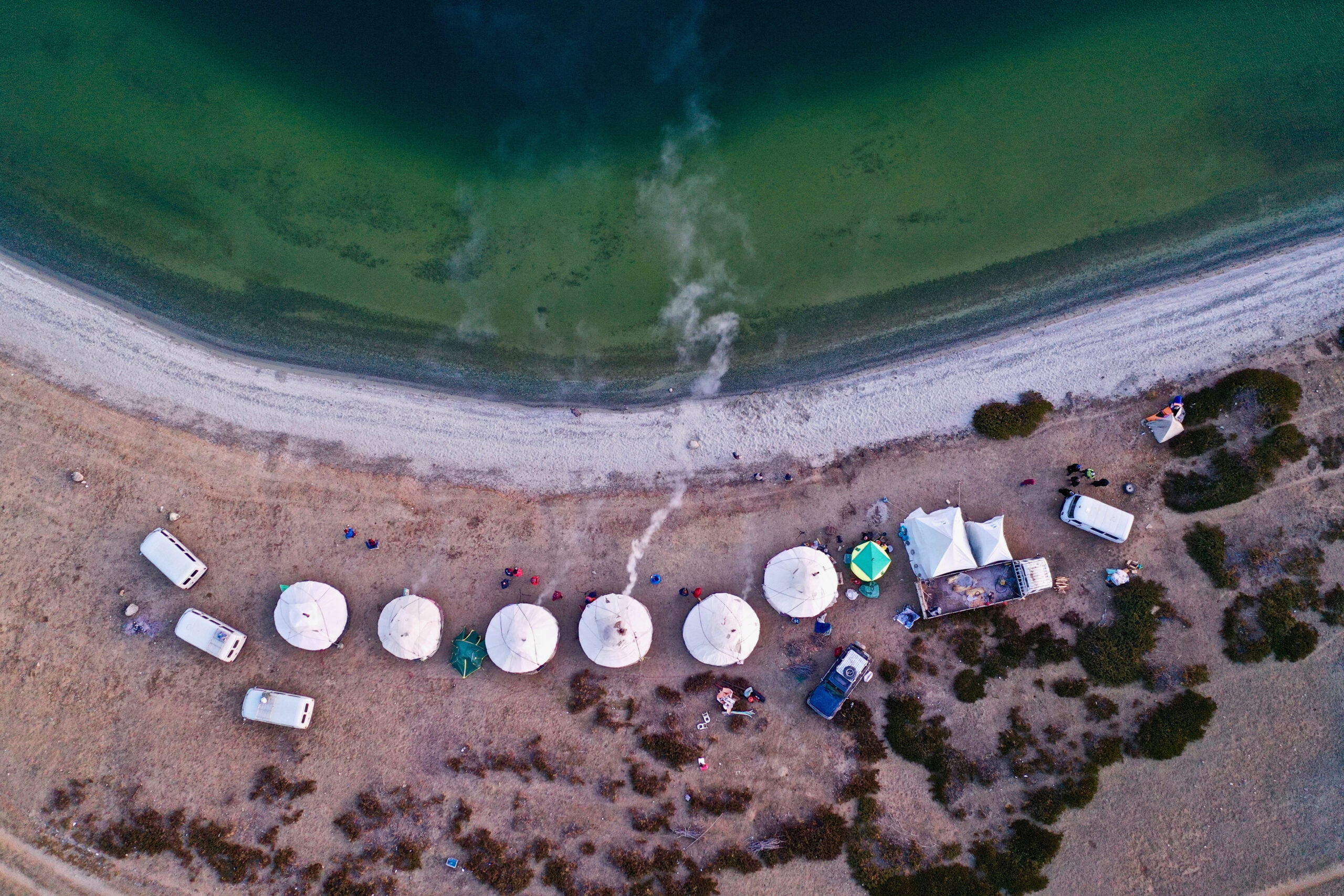 aerial shot of white tents on a beautiful beach