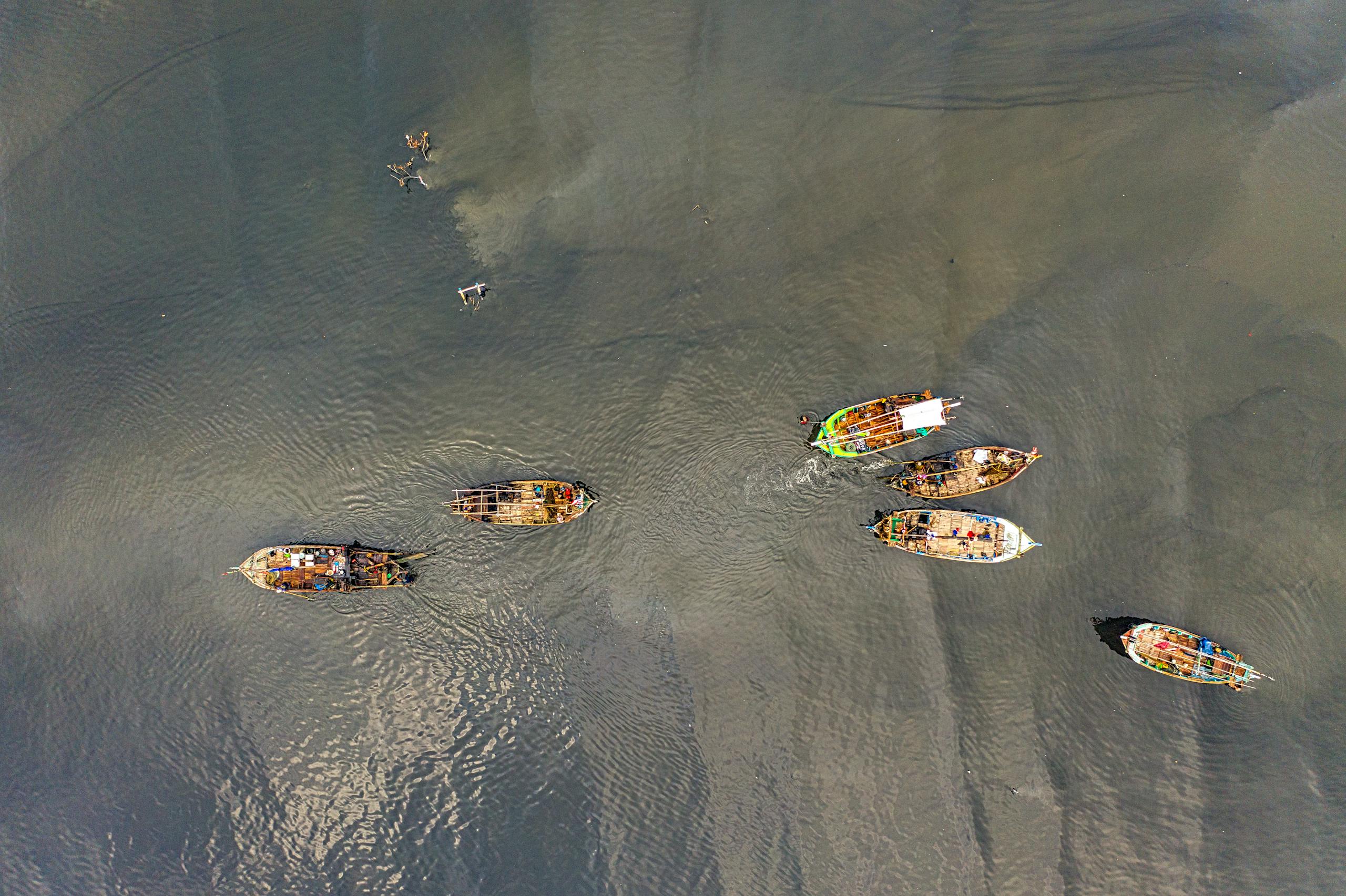 Drone shot capturing fishing boats in the calm ocean waters of Banten, Indonesia.
