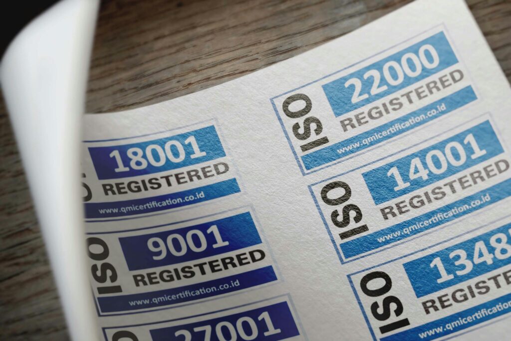 About Us ISO certification stickers with registration numbers on paper.