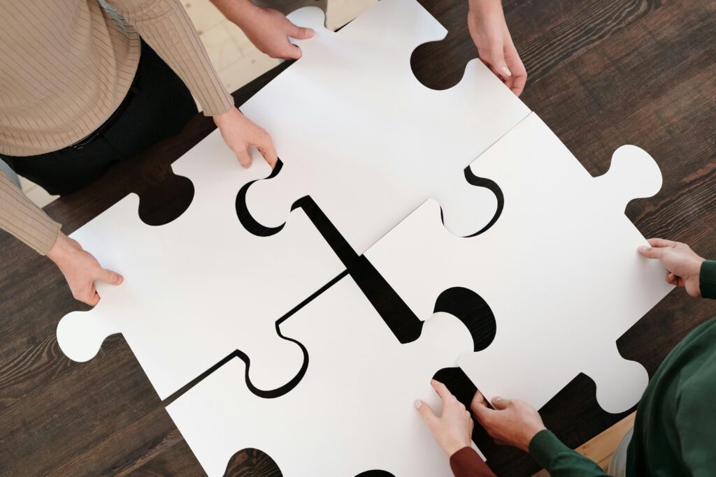 About Us Group collaborating on assembling large puzzle pieces symbolizing teamwork and unity.