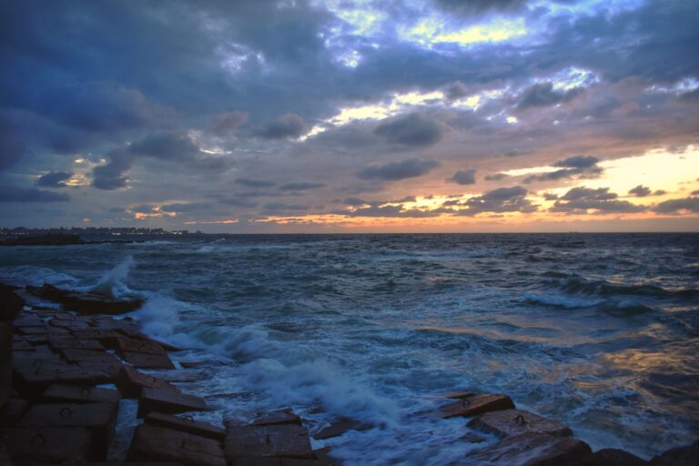 Captivating sunset over the Mediterranean Sea in Alexandria, highlighting clouds, waves, and vibrant skies.