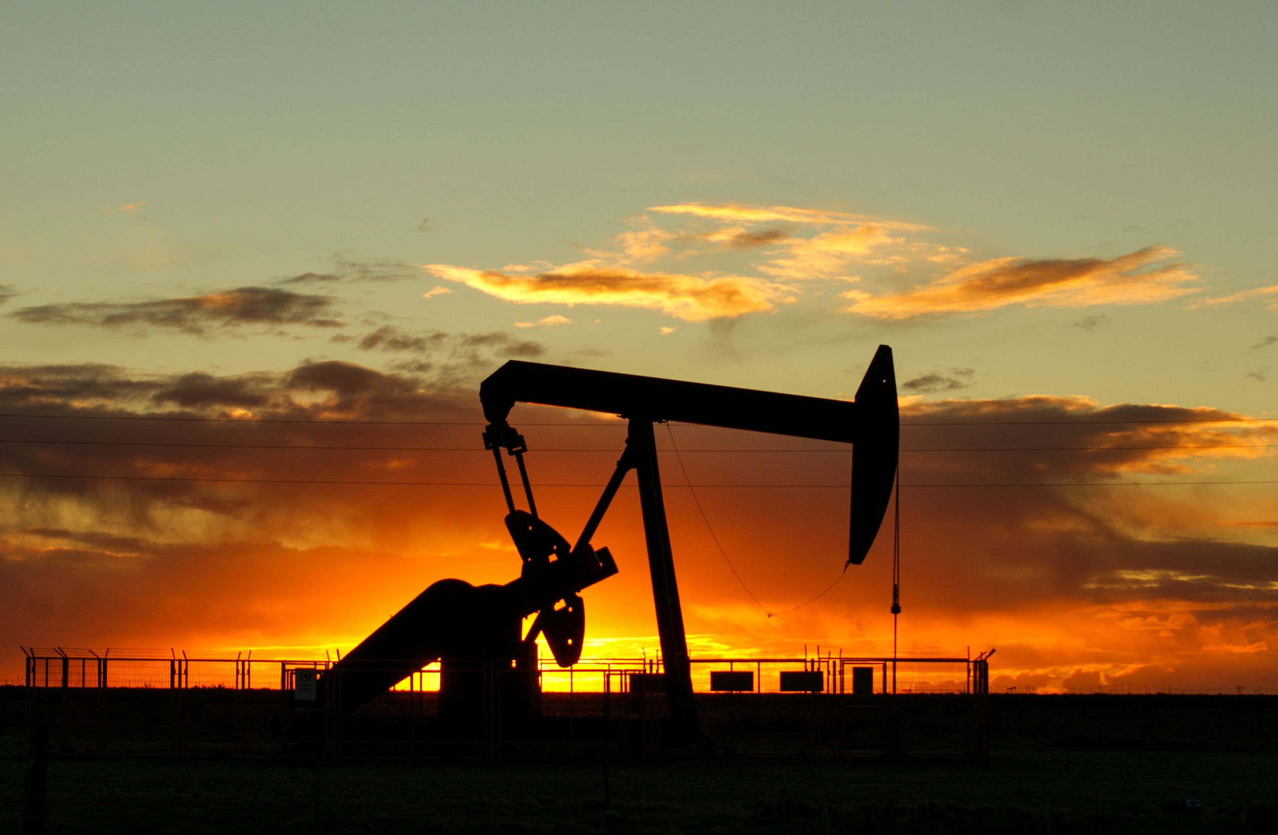 Environmental and Social Assessment Report (ESAR) for EF 2131 Dramatic silhouette of an oil pump jack against a vibrant sunset sky, emphasizing energy extraction.