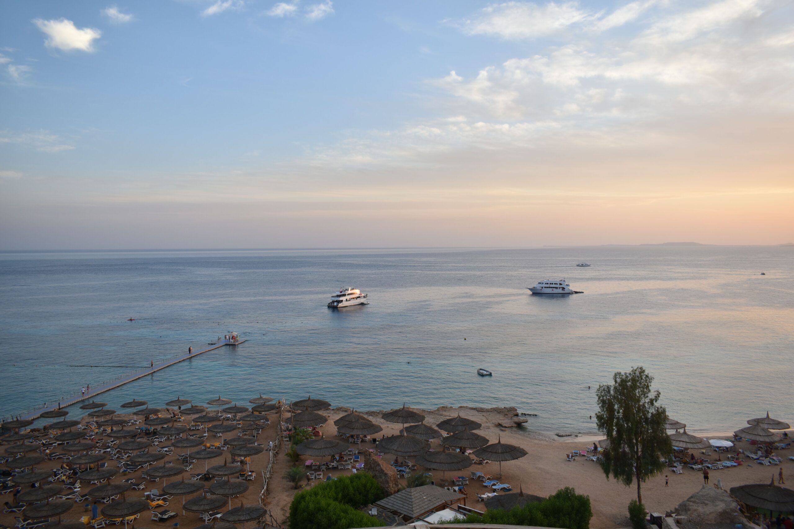 ESIA and ESMP for Green Sharm El Sheikh – Biodiversity Workstream Stunning aerial view of Sharm El Sheikh's beach and sea during sunset with boats and parasols.