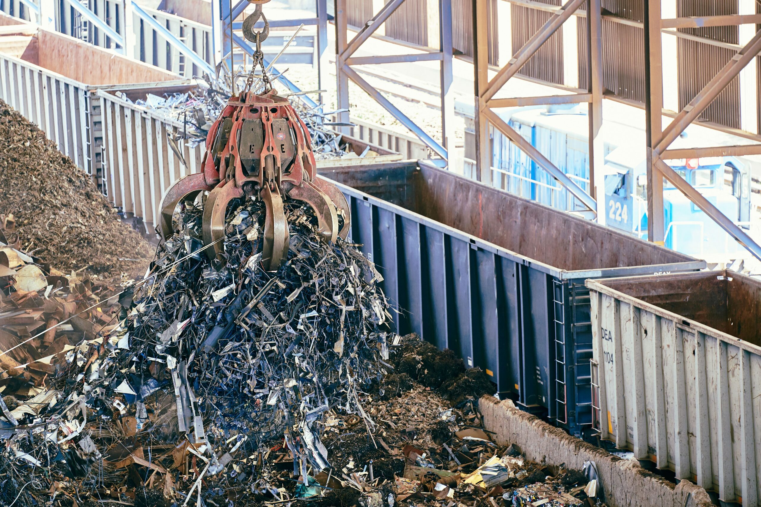 EIA, Air Dispersion and Noise Modelling for QD Metal Recycling Facility An industrial claw crane lifts metal scrap in a recycling facility, showcasing efficient waste management.