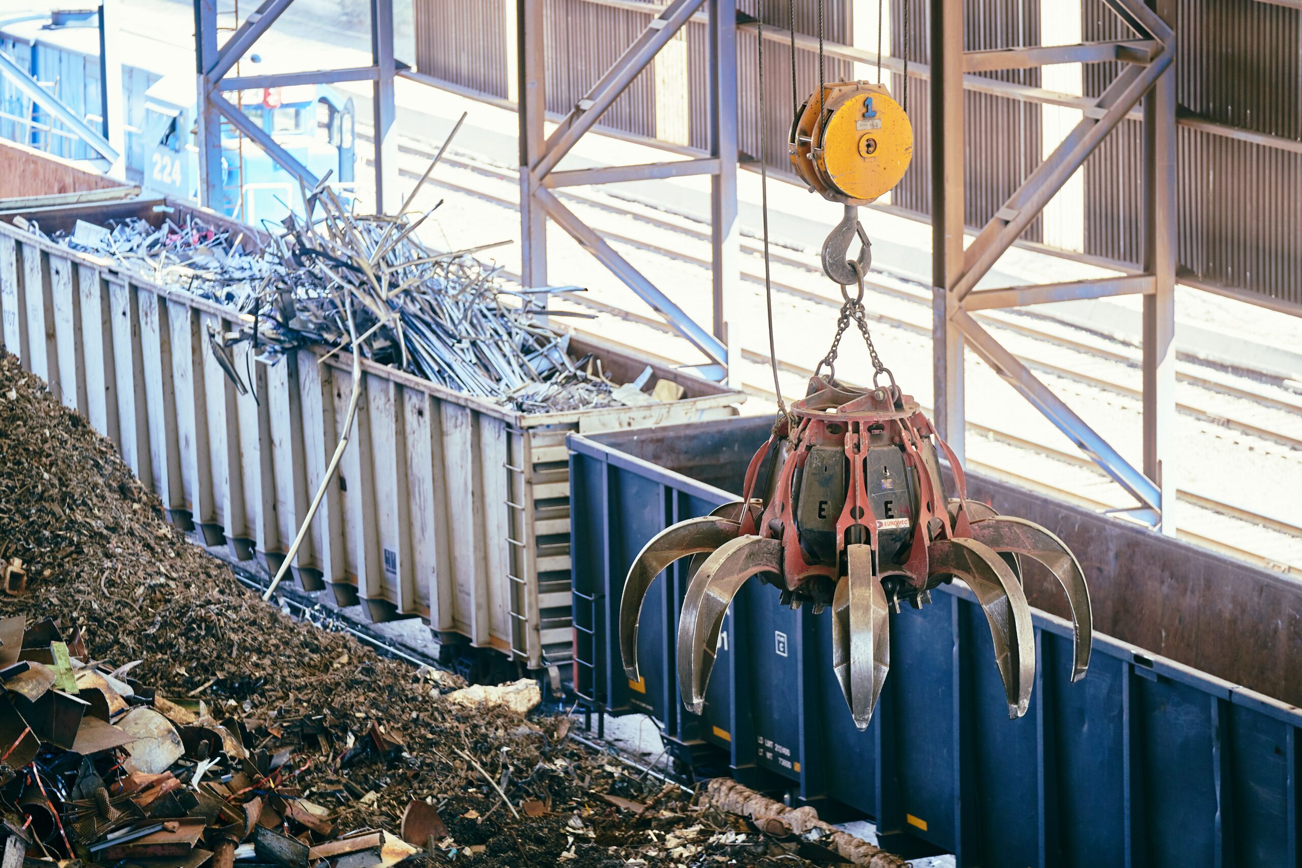 EIA, Air Dispersion and Noise Modelling for Technical Factory for Plastic Recycling Overhead crane sorting scrap metal in an industrial recycling facility.